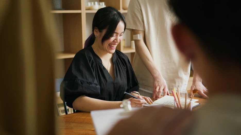 Una persona che scrive su un taccuino durante una sessione di brainstorming.